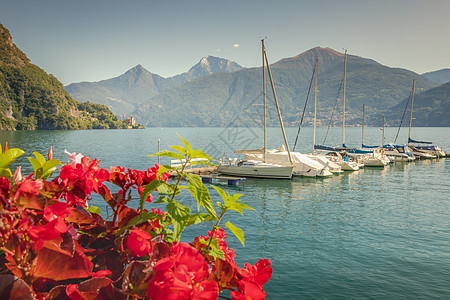 科莫湖海岸线和码头 在意大利阳光明媚的日落时配备快艇和帆船图片