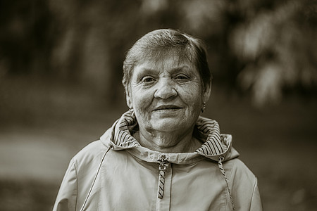 秋天公园中微笑的老女人的美丽肖像 高加索祖母看着照相机看 黑人和白人图片