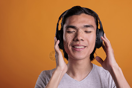 一个人在耳机中享受音乐 面部表情满意图片