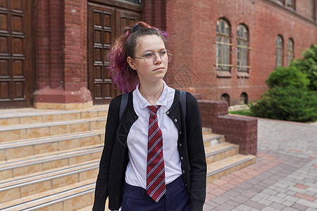 穿制服背着背包的女学生 建立学校背景青春期教育大学微笑中学女孩领带建筑孩子青年图片