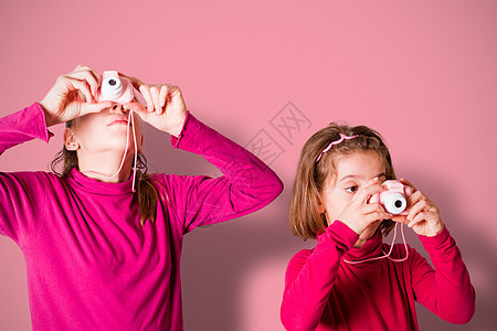 使用玩具摄影机拍摄照片的小女孩们的相片休闲探险家摄影女孩爱好享受学习照相机青少年镜片图片