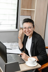 年轻的商业女雇员或经理使用计算机 看客户或雇员并微笑 混合工作办公室空闲 )请访问InfoFinland上的图片