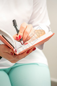 近距离的女医生治疗师在医务室的一个医疗笔记本上写下笔记卡片疾病医院工作诊断诊所摄影女性写作记事本图片