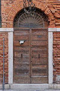 意大利威尼斯红砖建筑中的古董木制门图片