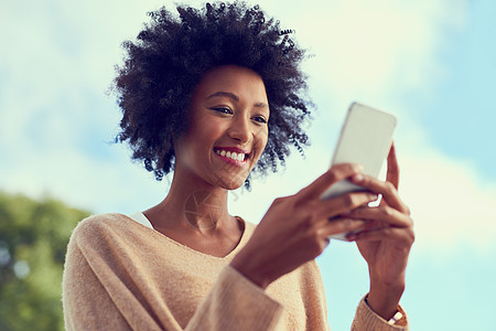 社交媒体上什么风声 一个年轻女性在外面用她的手机图片