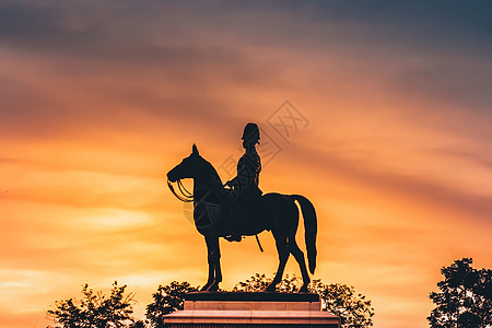 朱拉隆功国王拉玛五世骑马 在自然日落的天空背景上图片