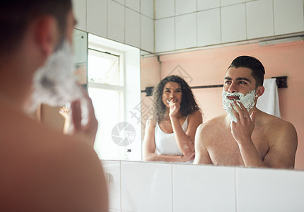 一个英俊的年轻人刮胡子 而他女朋友在浴室刷牙时 却在洗手间擦牙图片