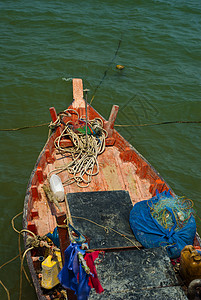 Wooden渔船在渔获返回后沿海漂流木头支撑假期绳索旗帜蓝色海洋工具海岸港口图片