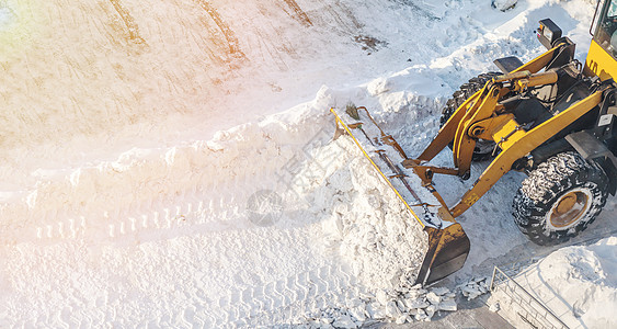 大橙色拖拉机除去路上的雪 清除人行道工作清洁工打扫暴风雪挖掘机运输推土机装载机车轮街道图片