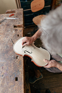 用刀子把小提琴打个洞 雕刻和雕刻音乐琴师工具乐器制造商奉献创造力修理世界中提琴图片