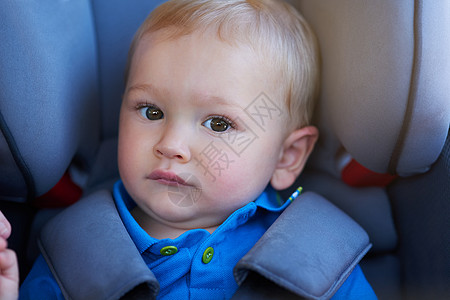 坐在汽车座椅上的可爱小男孩的肖像 他是个很可爱的小男孩背景