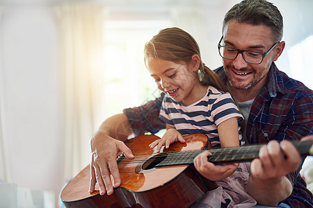 她值得花那么多时间 一个小女孩和她父亲一起弹吉他的吉他图片
