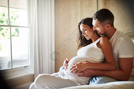 家庭纽带 丈夫和怀孕妻子一起坐在卧室里 坐在一起图片