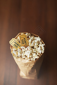 没有爆米花的电影不一样 一袋爆米花和两张木制背景的电影票背景图片