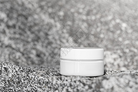 化妆品产品模拟在灰色石头背景的罐子里 用于日常护肤的乳液 护手霜或眼霜 美容包装样机 正视图 化妆品模型概念静物图片