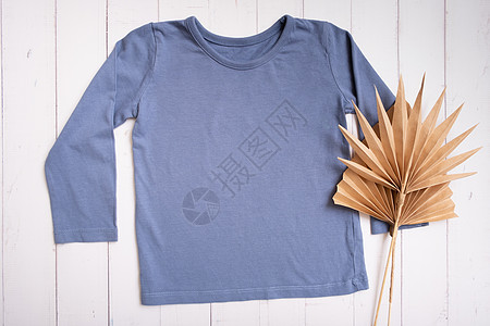 灰色儿童衬衫的顶端视图 在木制背景上为标识 文字或设计进行假冒图片