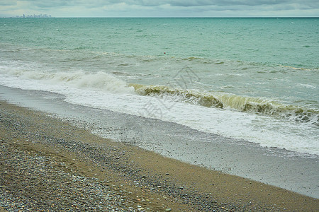 海景 海边有石子 海滩上有湿海岩块和宁静的海浪图片