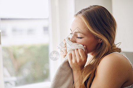 一个年轻女人 在家里闻着新鲜的洗涤物气味 我从她身上取出新的洗涤物香味图片