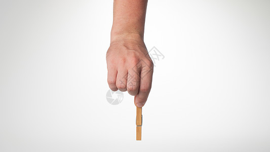 一个人的手握着一个木制手势衣物铺位 可以写作图片