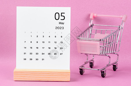 2023年5月的月历 用粉红色背景的购物车图片