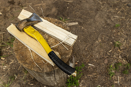 一根用塑料把手和木木木块在树桩上的斧头图片