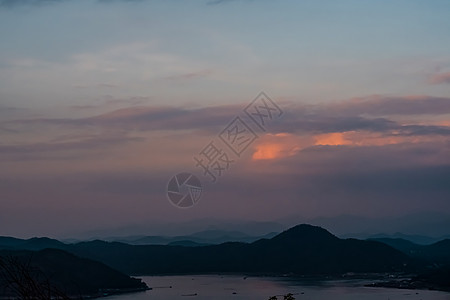 黄昏海景夜间日落时山景色的全景自然背景图示山脉风景橙子薄雾场景天空太阳森林旅行环境背景