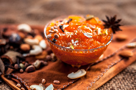 在黄麻袋表面的玻璃碗中保存着著名的芒果 即Murba或Murabba 还有干果和香料 带有背景模糊度的霍里佐塔尔射线甜点石头营养图片