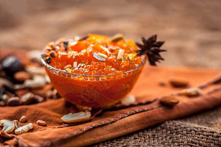 在黄麻袋表面的玻璃碗中保存着著名的芒果 即Murba或Murabba 还有干果和香料 带有背景模糊度的霍里佐塔尔射线糖浆杏仁美食图片