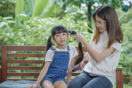 家庭快乐的美丽母亲 妇女在家里户外露面时梳理女儿的头发梳子刷子朋友们妈妈成人房间理发时间孩子幸福图片