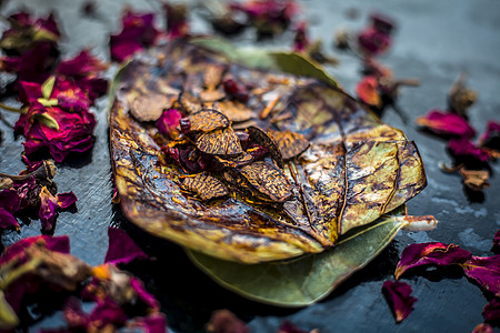印度著名传统马萨拉锅或黑地面的梅沙煎饼附近 有些玫瑰水由涂层的苏夫 苏帕里 甜菜和一些椰子粉组成经文水果烟草教义树叶平底锅点心牙图片