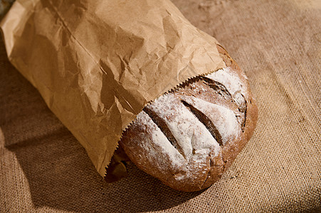 静物 用麻布桌布放在桌上生态袋中的全麦健康黑麦酵母面包的顶部视图图片