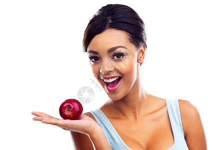 每天一个苹果会给你带来奇迹 一个穿着运动服的年轻女子拿着一个苹果 对着镜头微笑图片