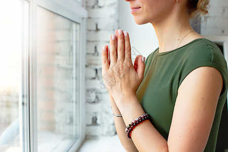 穿绿色T恤的女孩 在瑜伽里装近身 把手掌折在胸前冥想灵活性沉思感激练习活动身体锻炼手镯女性图片