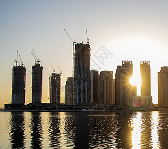 奉化溪口迪拜Jadaf地区日出时 杜拜溪口港的建造部分完成 在迪拜Jadaf地区全景投资地标天际财产商业太阳天空玻璃财富背景