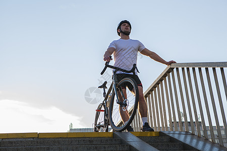 城里的男骑自行车者碎石齿轮运动街道天空车辆运输安全自行车头盔图片