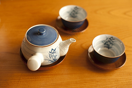 日式茶壶和木制桌上的杯子背景图片