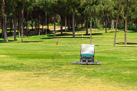 高尔夫球场和收集高尔夫球的高尔夫球车 高尔夫俱乐部练习场上的 Ballpicker驾驶集电极运输机器车辆大车拖拉机游戏草皮运动图片