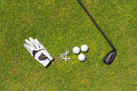 高尔夫球场绿草上高尔夫设备的顶视图 平躺的高尔夫球杆 球 手套 T 恤球道场地高尔夫球草地闲暇球具配饰娱乐爱好运动图片