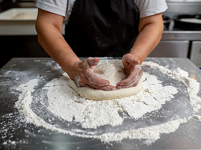 女人在不锈钢柜上做比萨饼粉末烹饪木板食物厨师馅饼家务糕点面粉美食图片