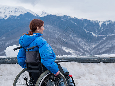 穿轮椅的白种女人 在冬天在山上旅行椅子保健动机机动性疾病女性事故健康旅游山脉图片