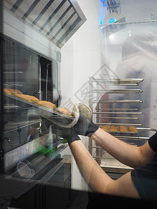 在蛋糕实验室专业烤炉里 烤一大堆饼干生产设计师面包房营养手套女性糖果作坊烹饪诱惑图片