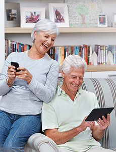 她需要电话簿 一位年长的女士发短信 而她的丈夫却在数字平板电脑上晃荡背景图片