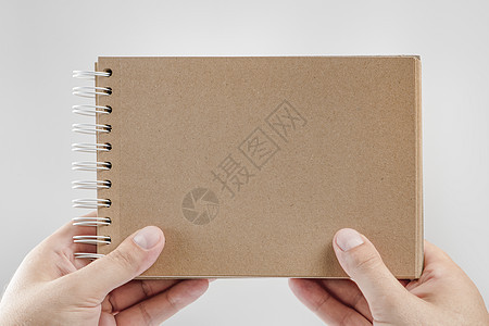 手拿记事本 白色背景中一名男子手中的空白记事本 手里拿着一本书 没有文字 一个男人拿着一本空白封面的书图片