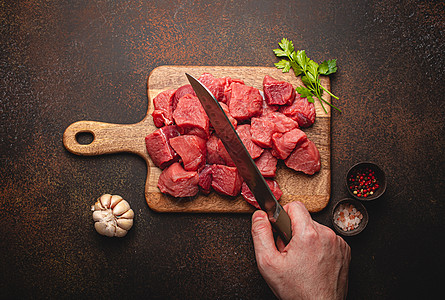 雄性手在木板上用立方体切生牛肉肉屠夫牛扒厨房牛肉腰部羊肉男人砧板美食烹饪图片