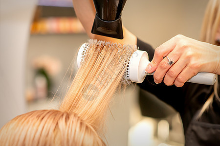 专业理发师干头发 在美容院有理发机和圆梳子女性职业客户美容师吹风机刷子工具发型烘干机沙龙图片