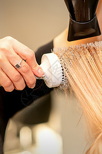 专业理发师干头发 在美容院有理发机和圆梳子治疗服务理发造型沙龙吹风机顾客造型师理发店金发图片