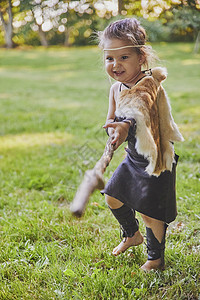 身着原始人服装的可爱婴儿 配有作战人员国籍动物戏服护身符乐趣荒野情感头巾女儿背景图片