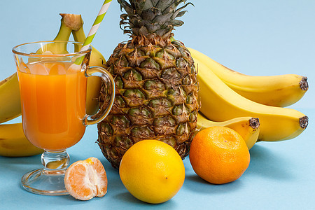 新鲜热带水果和蓝色背景的果汁杯子菠萝食物销售甜点团体橙子叶子营养小吃饮食图片