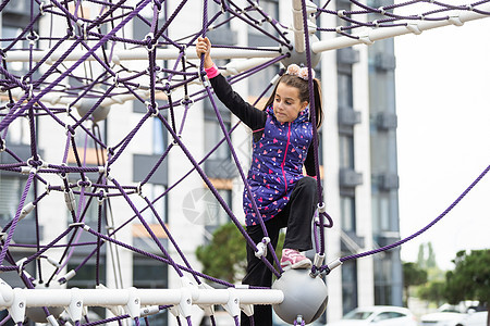 在操场上一个小女孩的肖像 女孩在迷宫里玩耍孩子蹦床安全运动生日绳索游戏女学生活动幼儿园图片