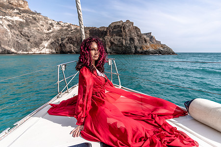 夏日在游艇上穿着红色礼服的中年女子 有吸引力的中年妇女 豪华暑假冒险 户外活动旅行方向盘航行船长女性车轮娱乐队长女孩女士图片